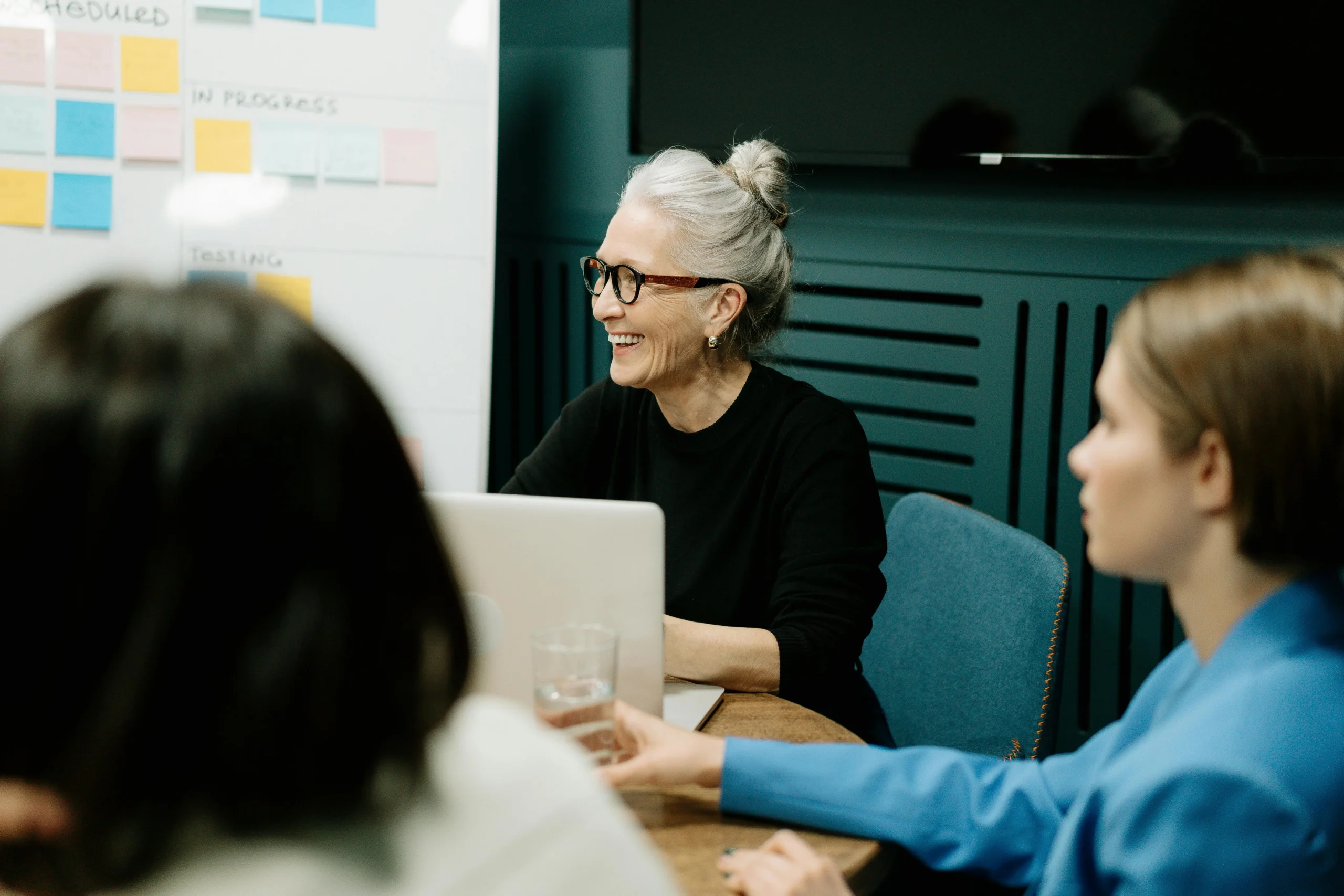 a woman smiling in a strategy meeting with other coworkers
